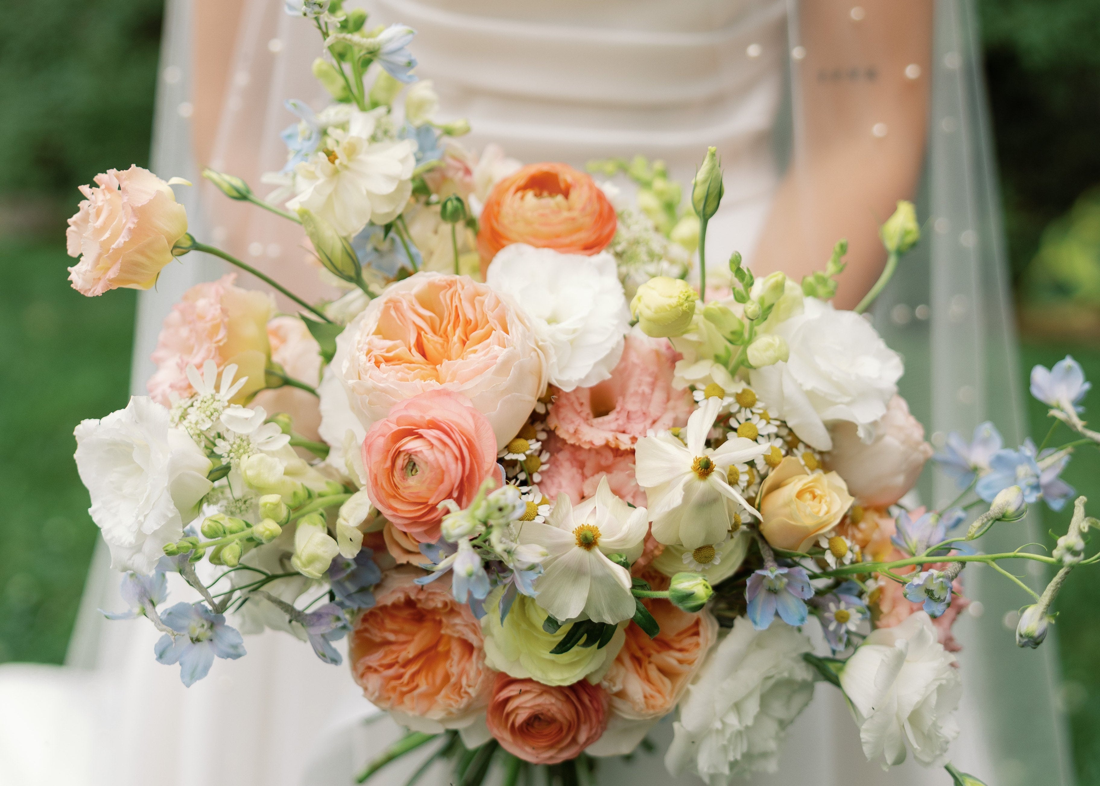 Bride holding a bouquet of flowers with a blurred green background