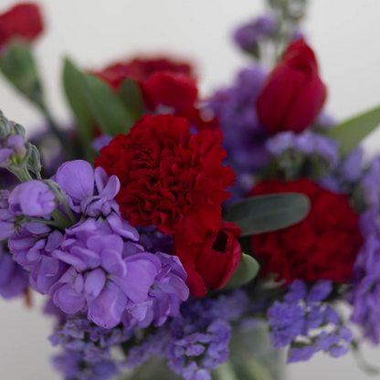 A small, sweet arrangement of flowers, accented with greenery and wrapped symbolizing love and affection for Valentine’s Day.