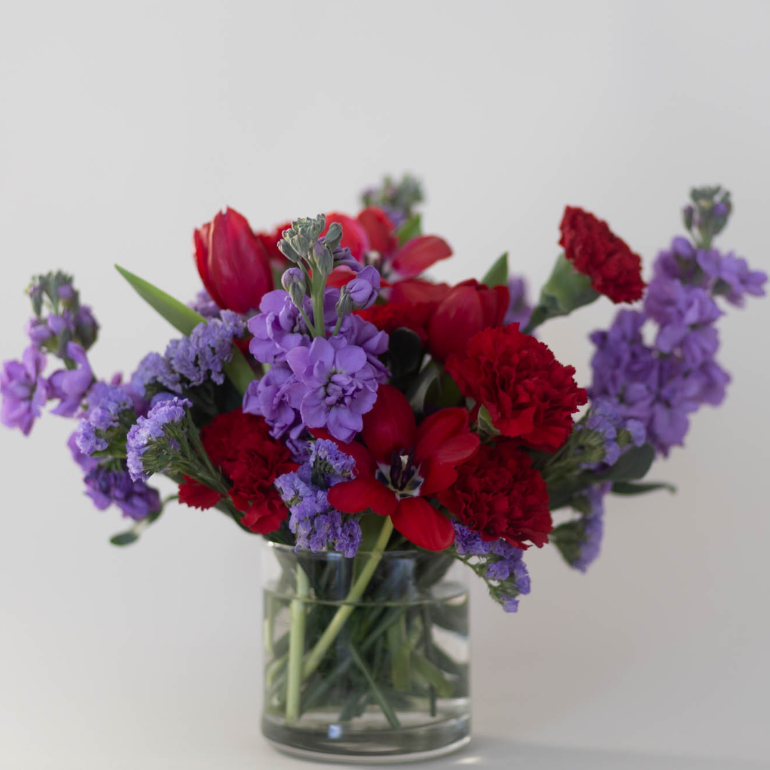 A beautiful Valentine’s Day centerpiece featuring hand picked flowers with accents of greenery in a stylish vase.